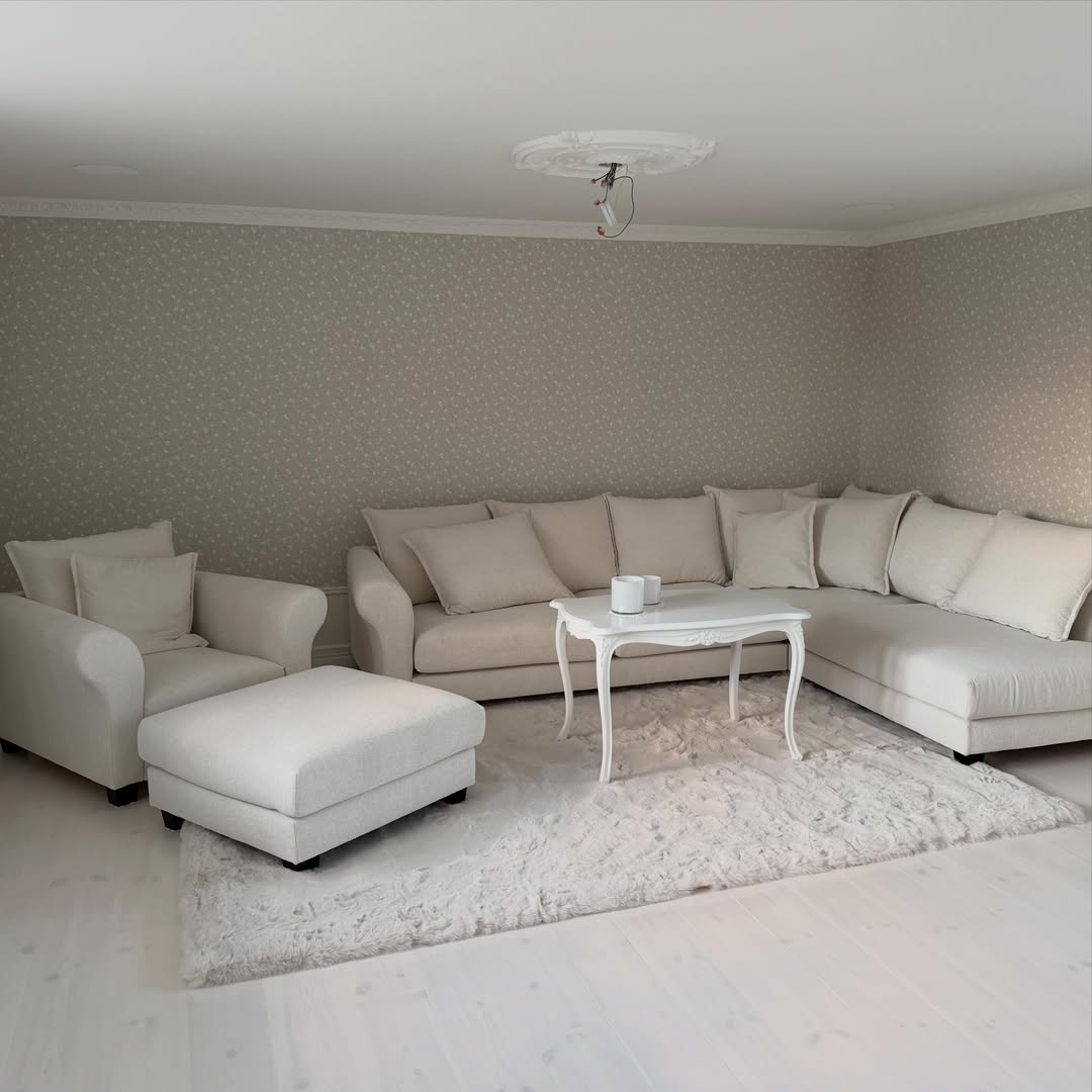 Ljust vardagsrum med beige soffgrupp efter renovering