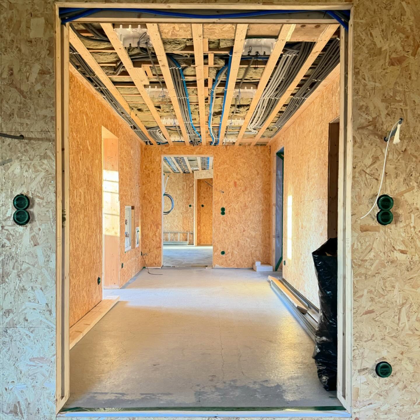 Hall i stomme med öppen takstol och installationsrör